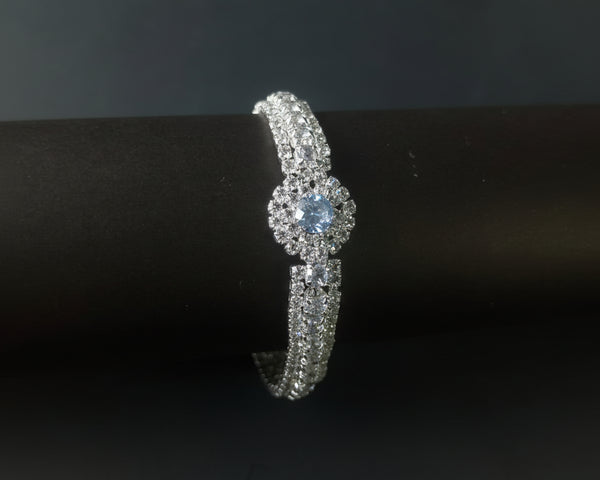 Silver ring with a central blue gemstone on a black background